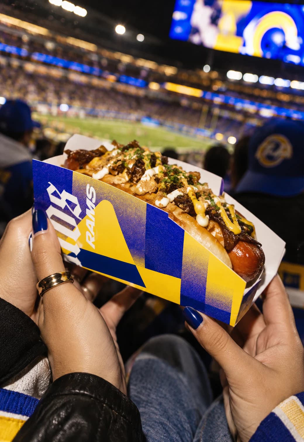 Rams-branded hot dog held up in the stands