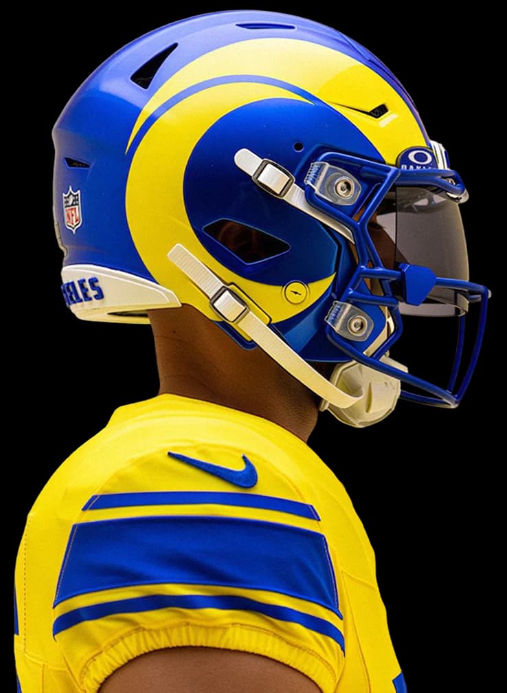 A Rams player in the sol jersey and helmet, in profile