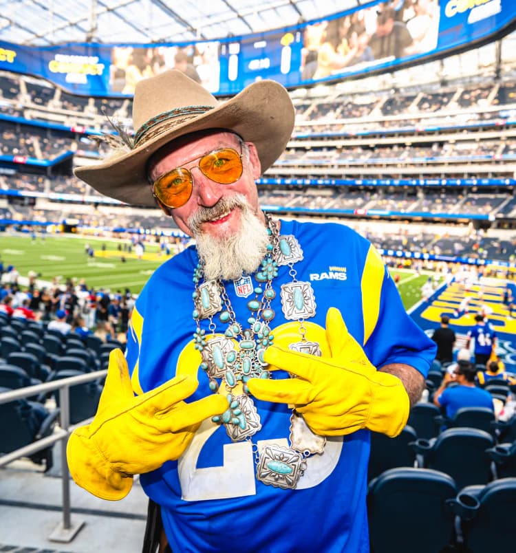 Fan in a cowboy hat and Rams gloves in the stands