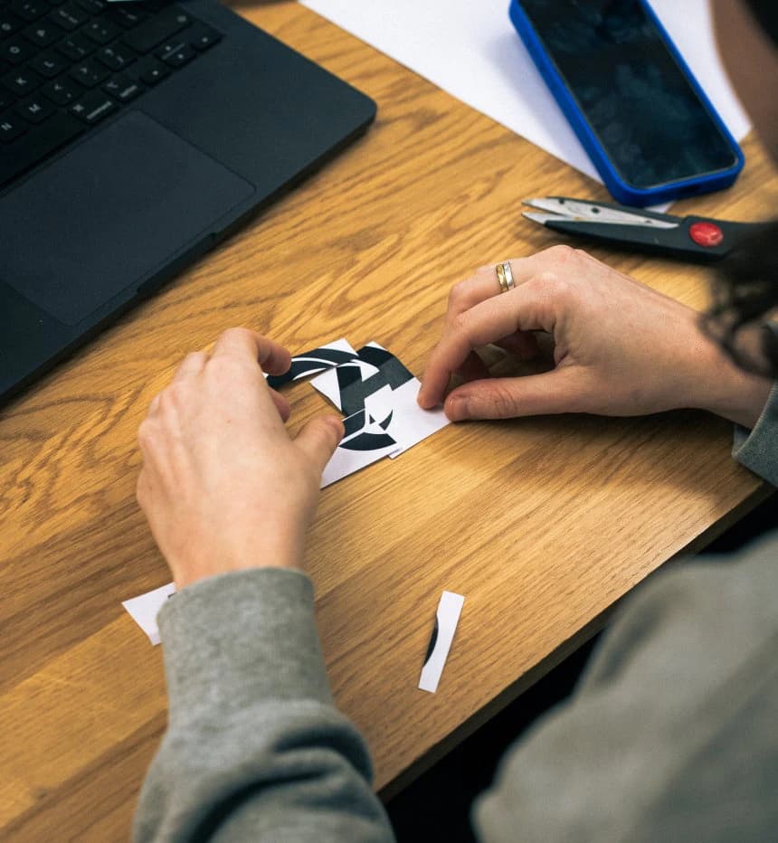 Hands placing a Rams horn sticker on a laptop