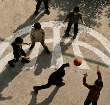 Overhead view of players on a court painted with the Project B arc mark