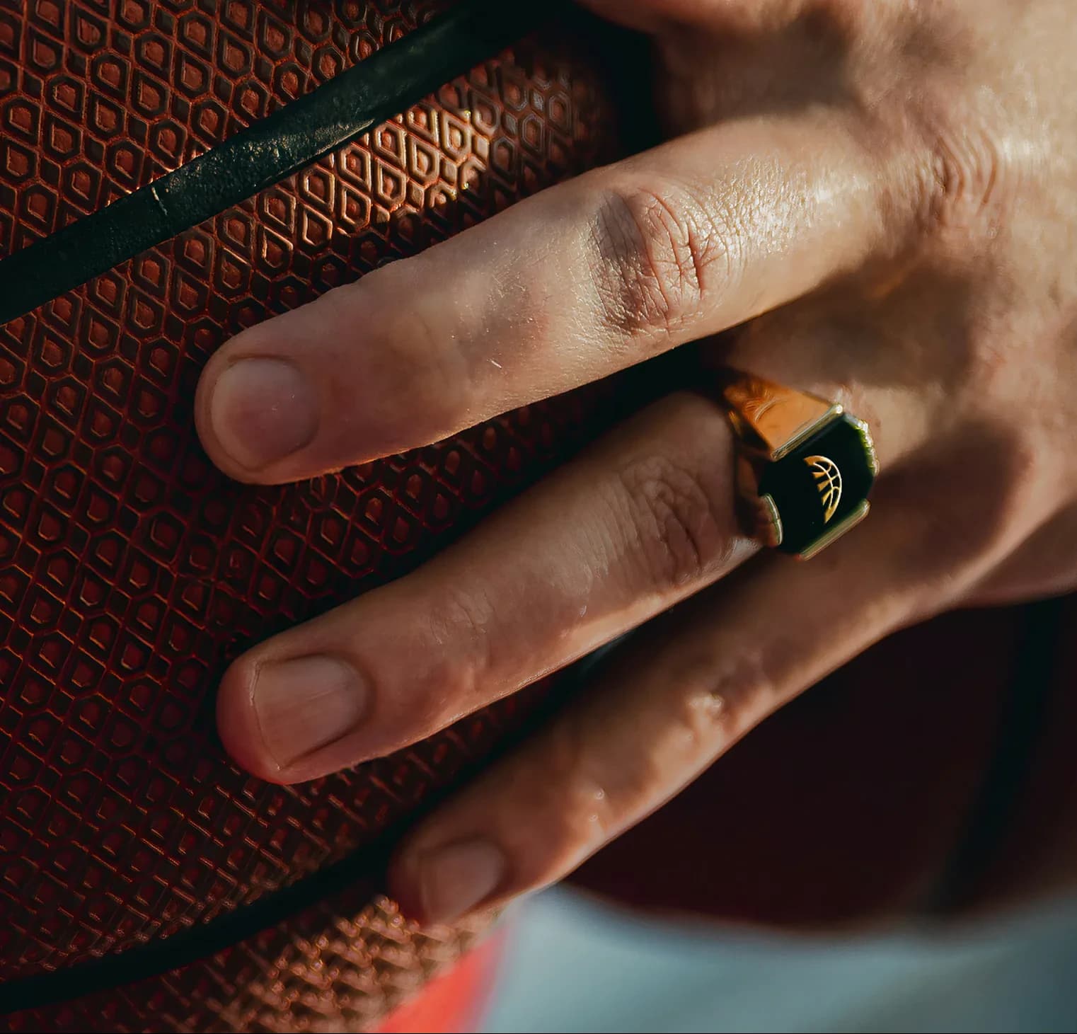 Hand on a basketball wearing a Project B signet ring