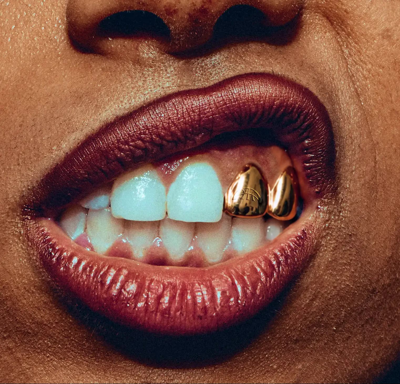 Close crop of a smile with gold Project B grillz