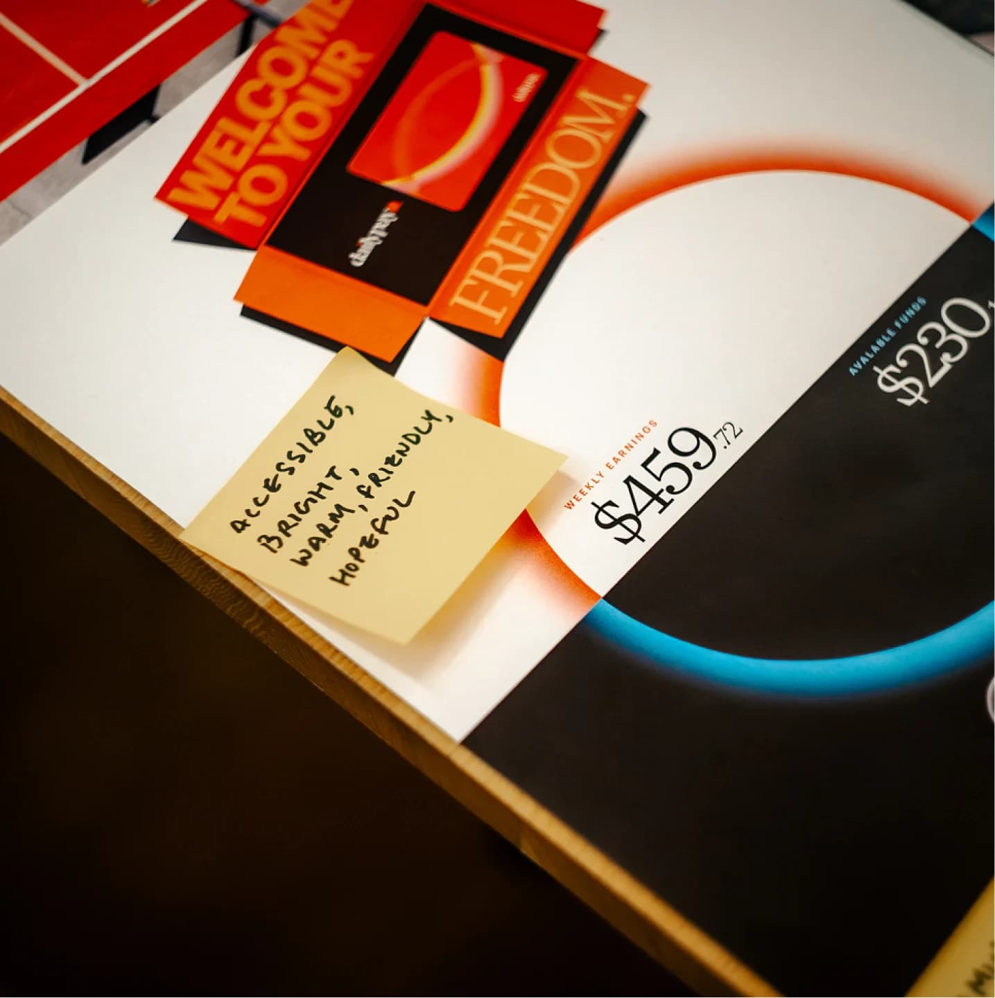 Printed boards on a wooden table, a post-it reading 'accessible, bright, warm, friendly, hopeful'