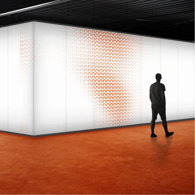 A white-walled corridor with an orange floor and an arch-pattern wall, a figure walking