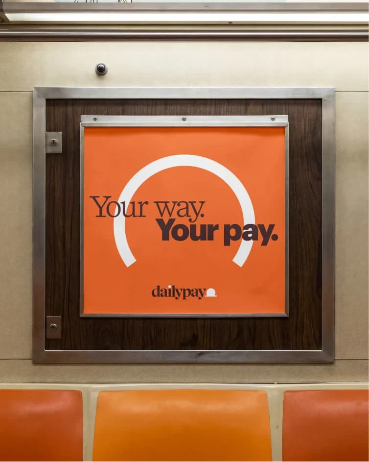 A framed subway-car poster reading 'Your way. Your pay.' above the dailypay wordmark