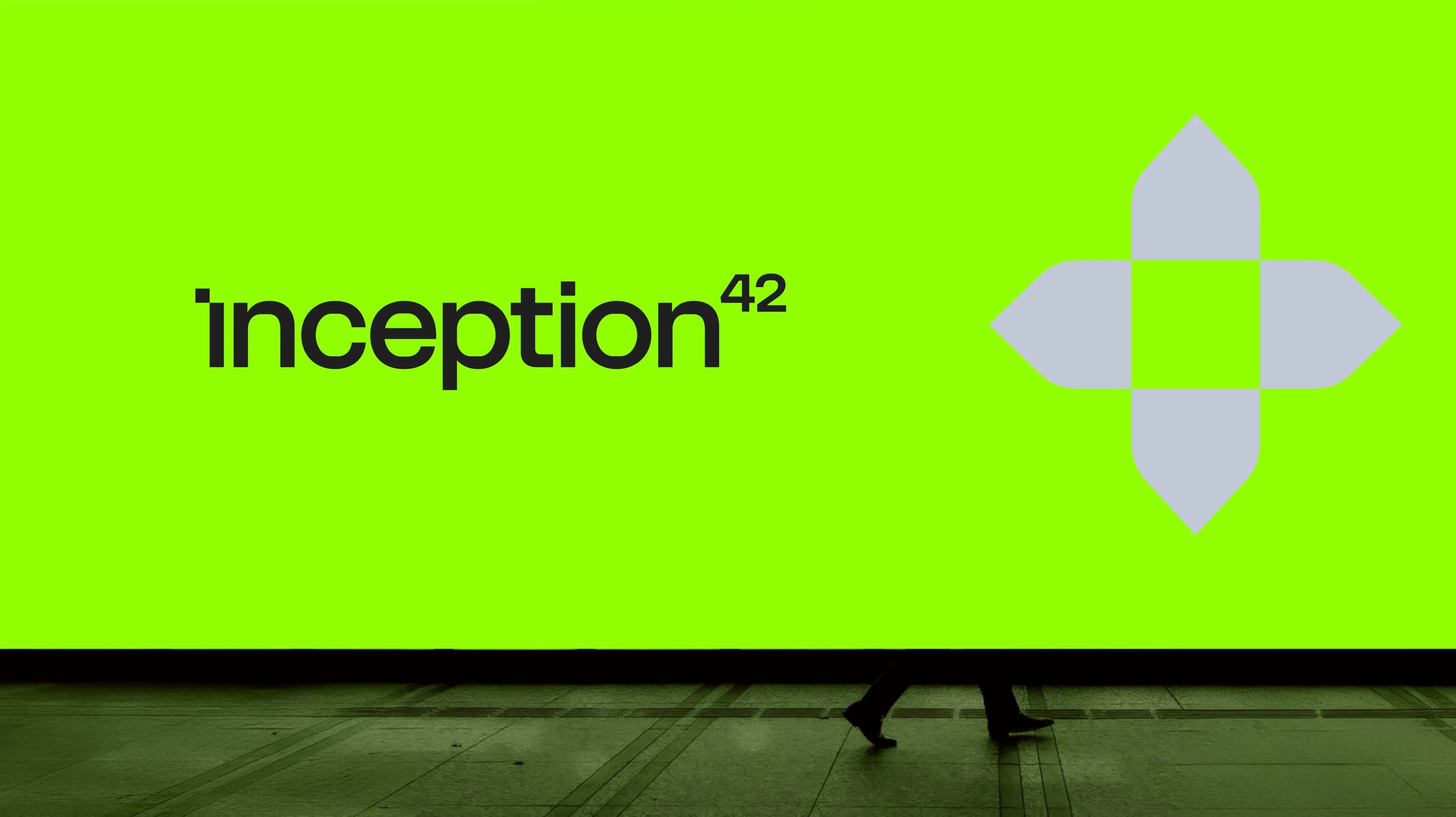 An Inception42 billboard in a station as a commuter walks past
