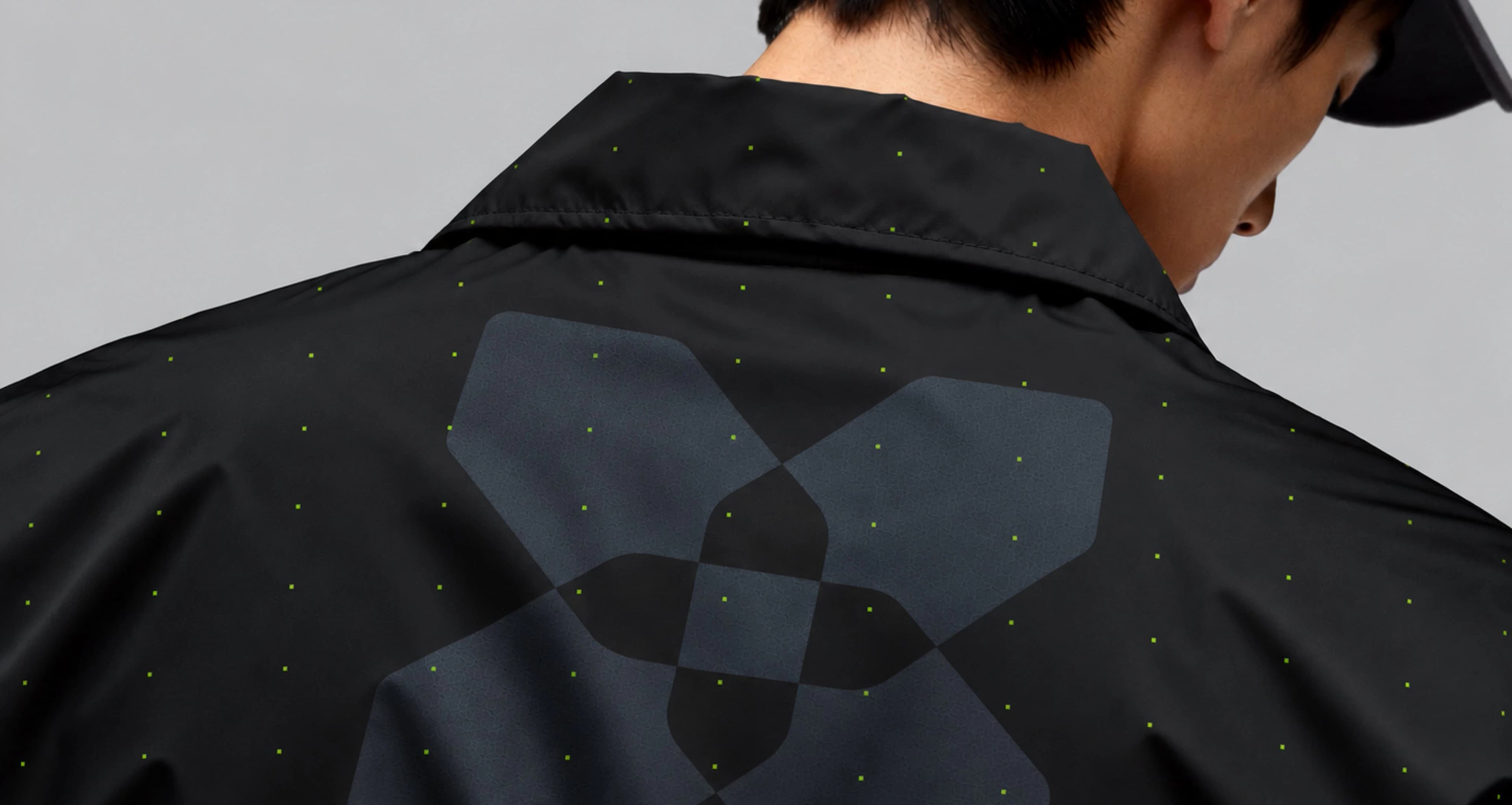 The Inception42 mark on the back of a black jacket, its fabric scattered with green points